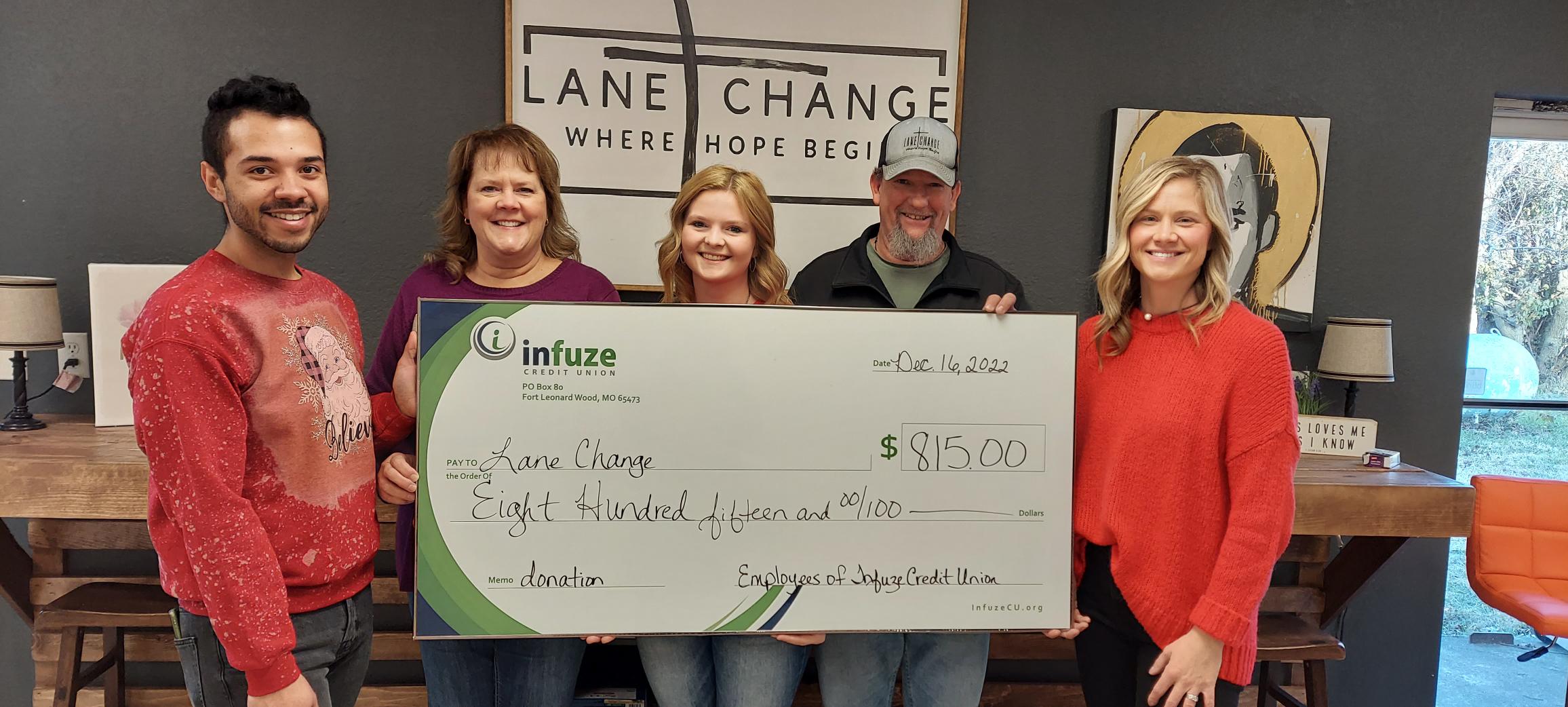 Five people holding a donation check.