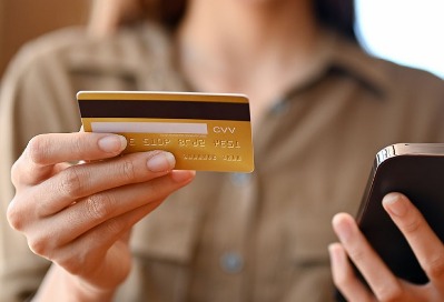 woman holding credit card and phone.