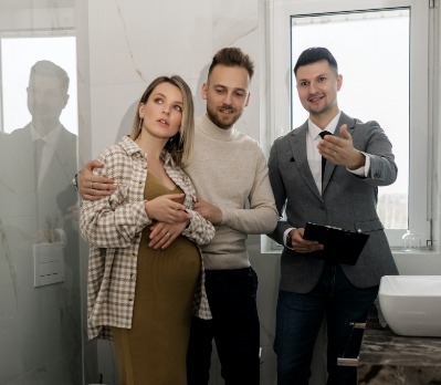 man with clipboard showing a couple a bathroom.