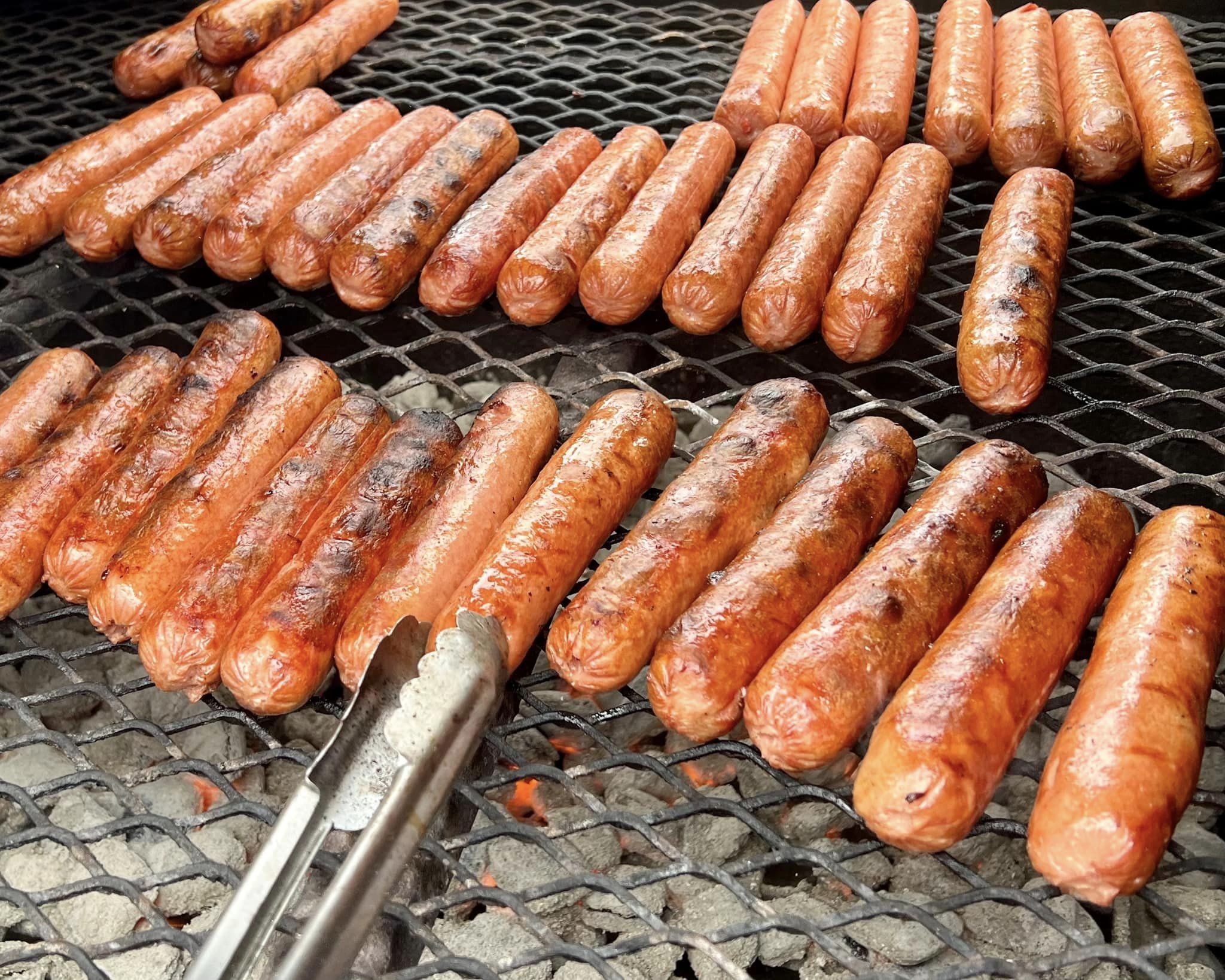 Hotdogs on a grill.