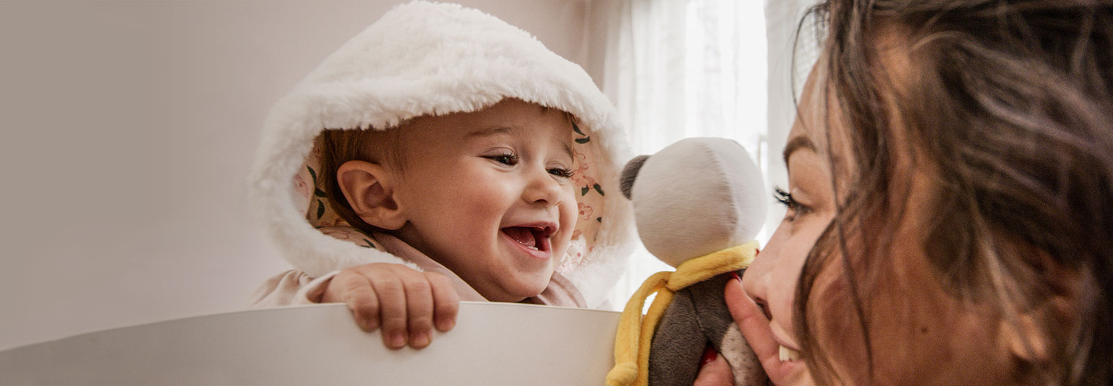 Baby looking at mom playing with a toy
