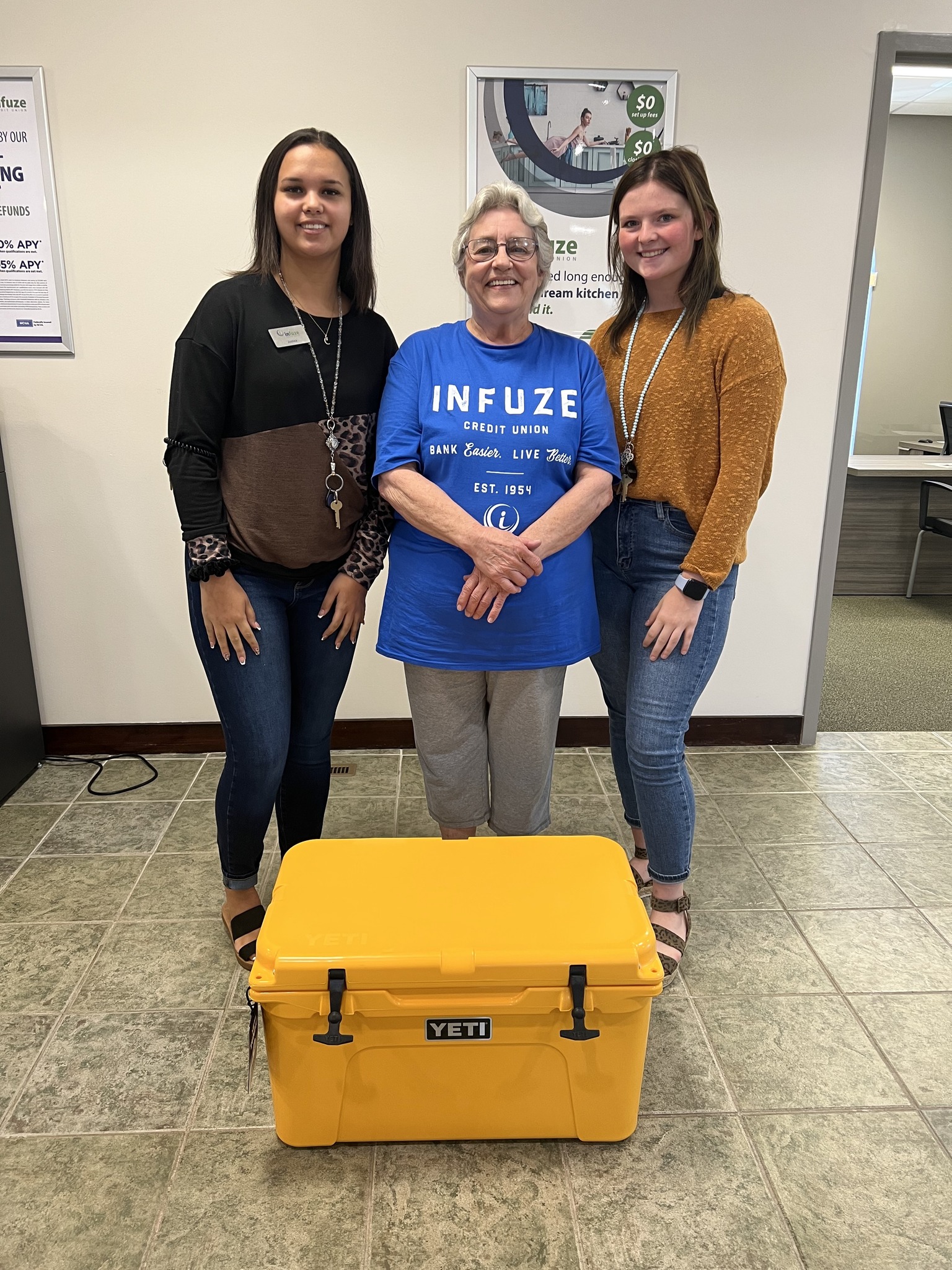 Three women standing in front of ice chest.