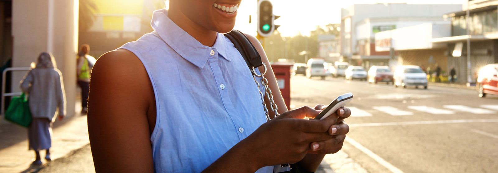 a woman smiling while holding her cell phone