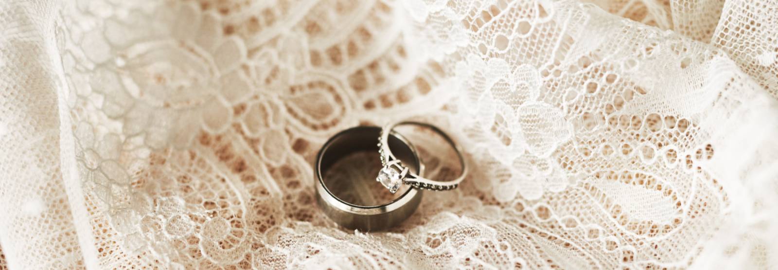 wedding bands on a white lace material