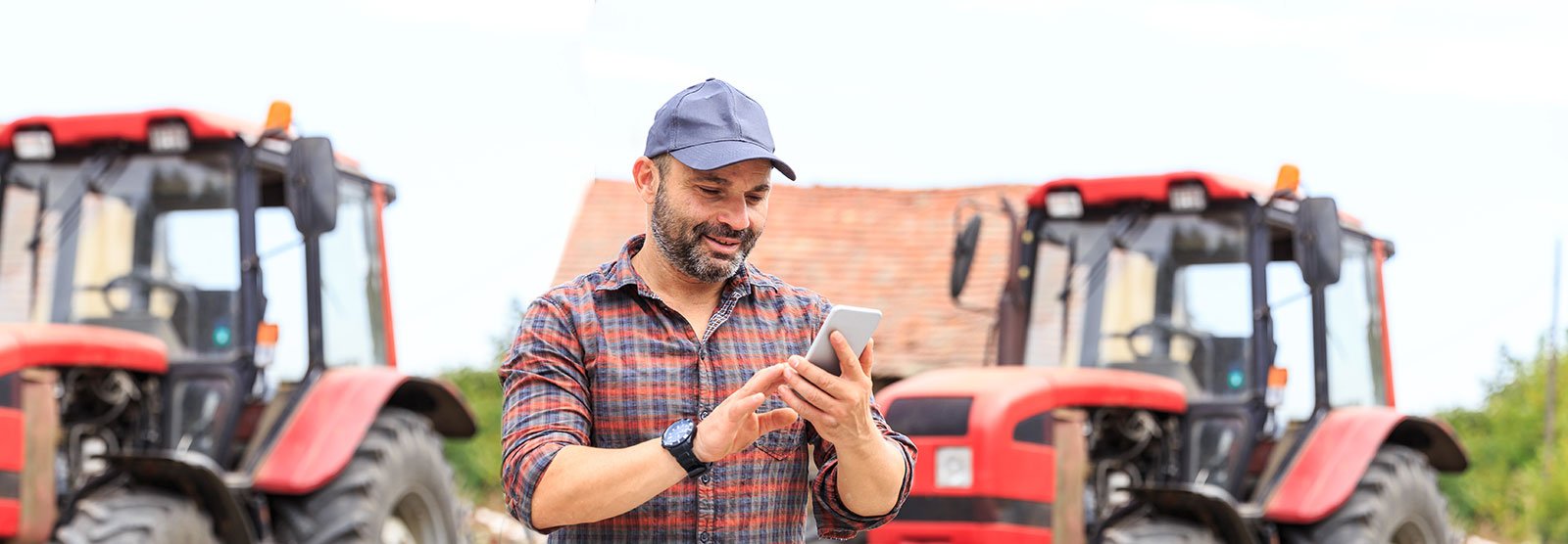 male farmer checking his cell phone on his land.