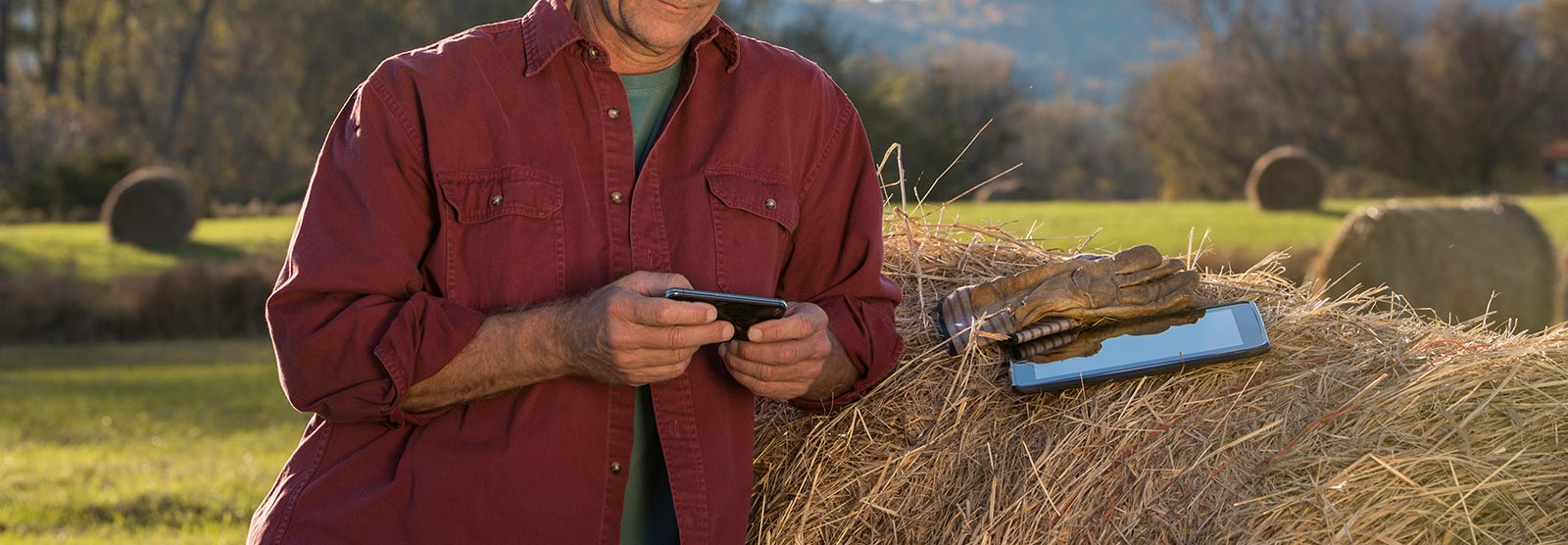 Farm owner with phone and tablet.