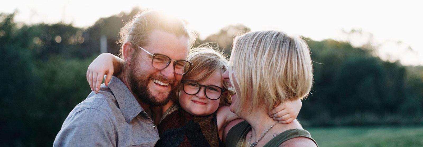 a family hugging outdoors