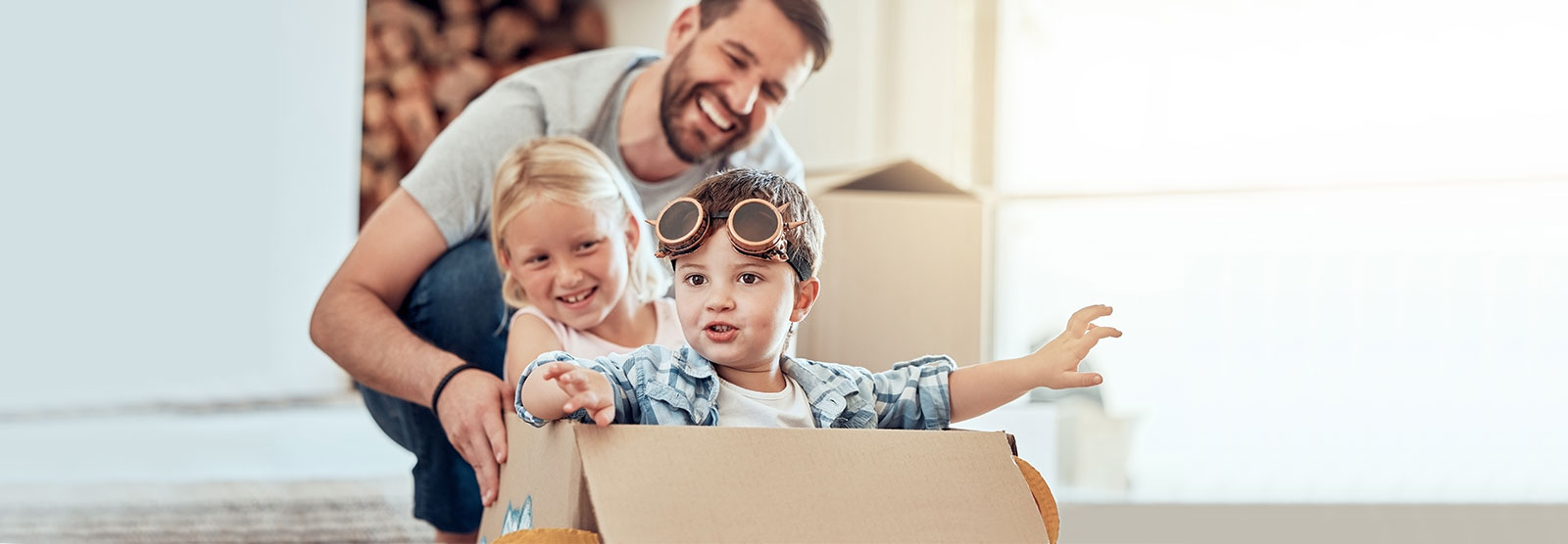 Two kids playing in box with dad.