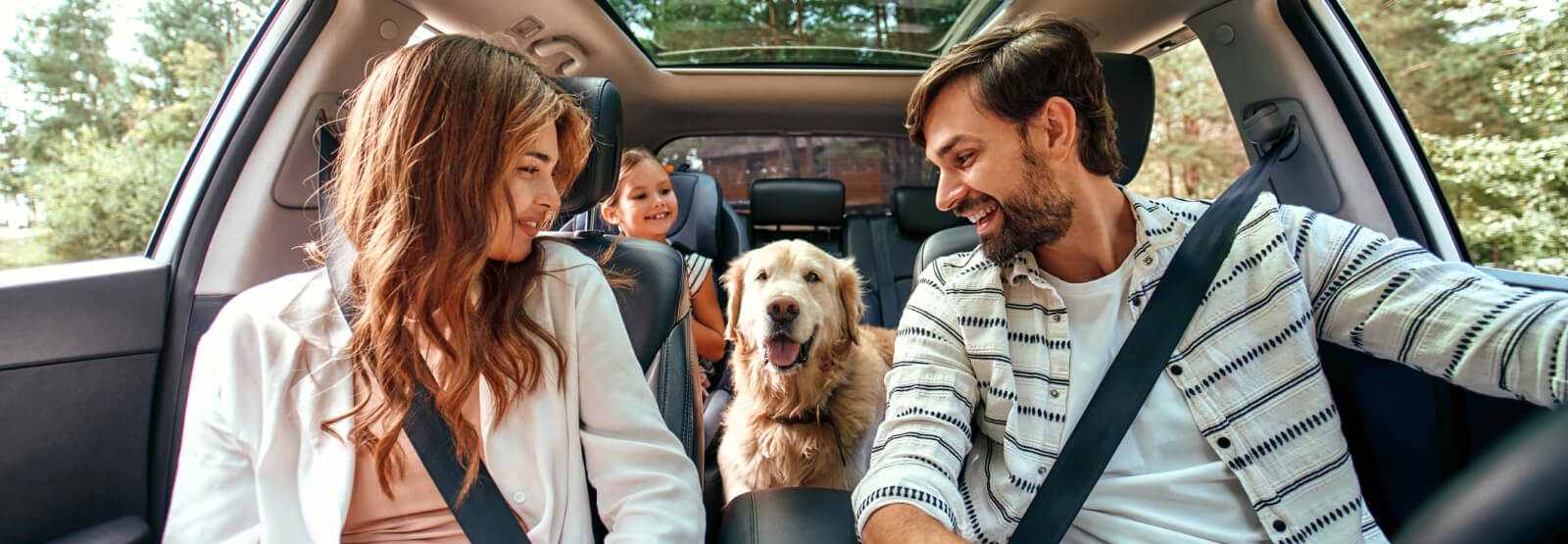 family of 3 with their dog in a vehicle