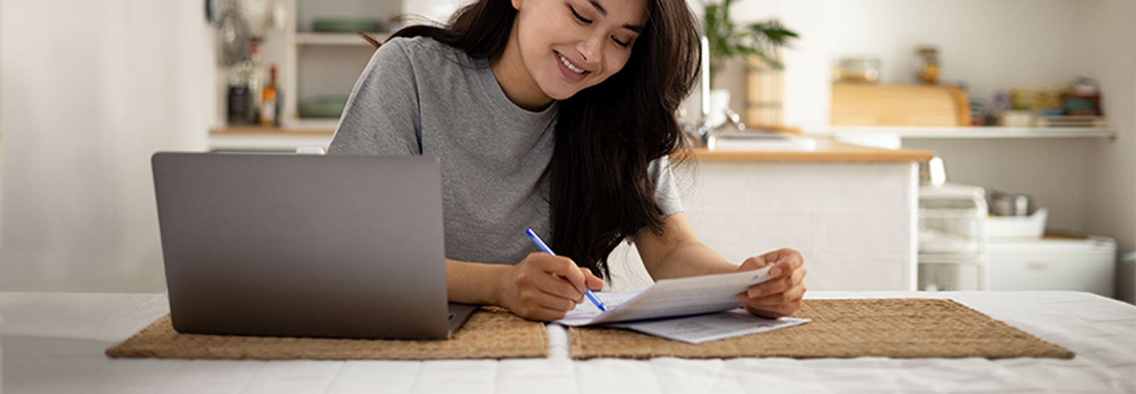 Woman paying bills at kitchen table