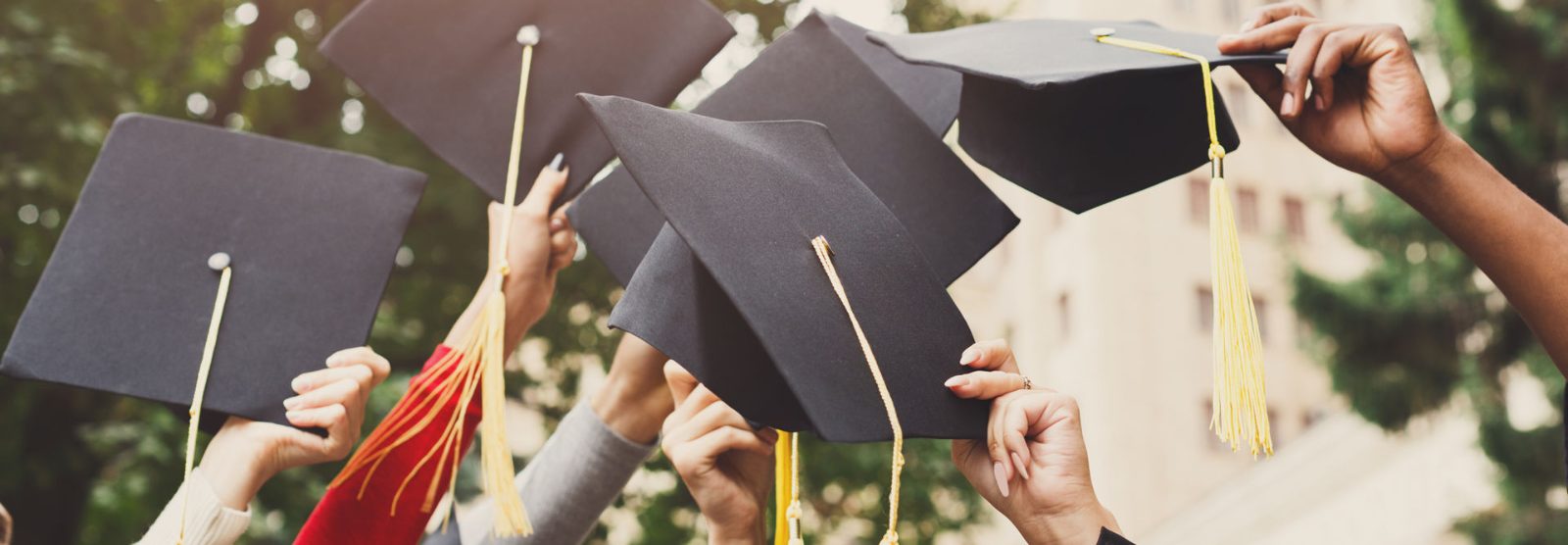 graduates holding their caps in the air