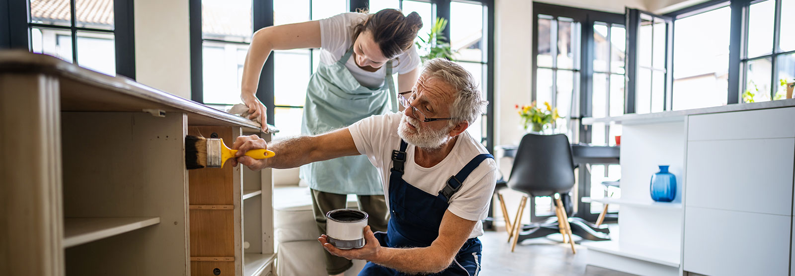 Man and woman painting shelves.