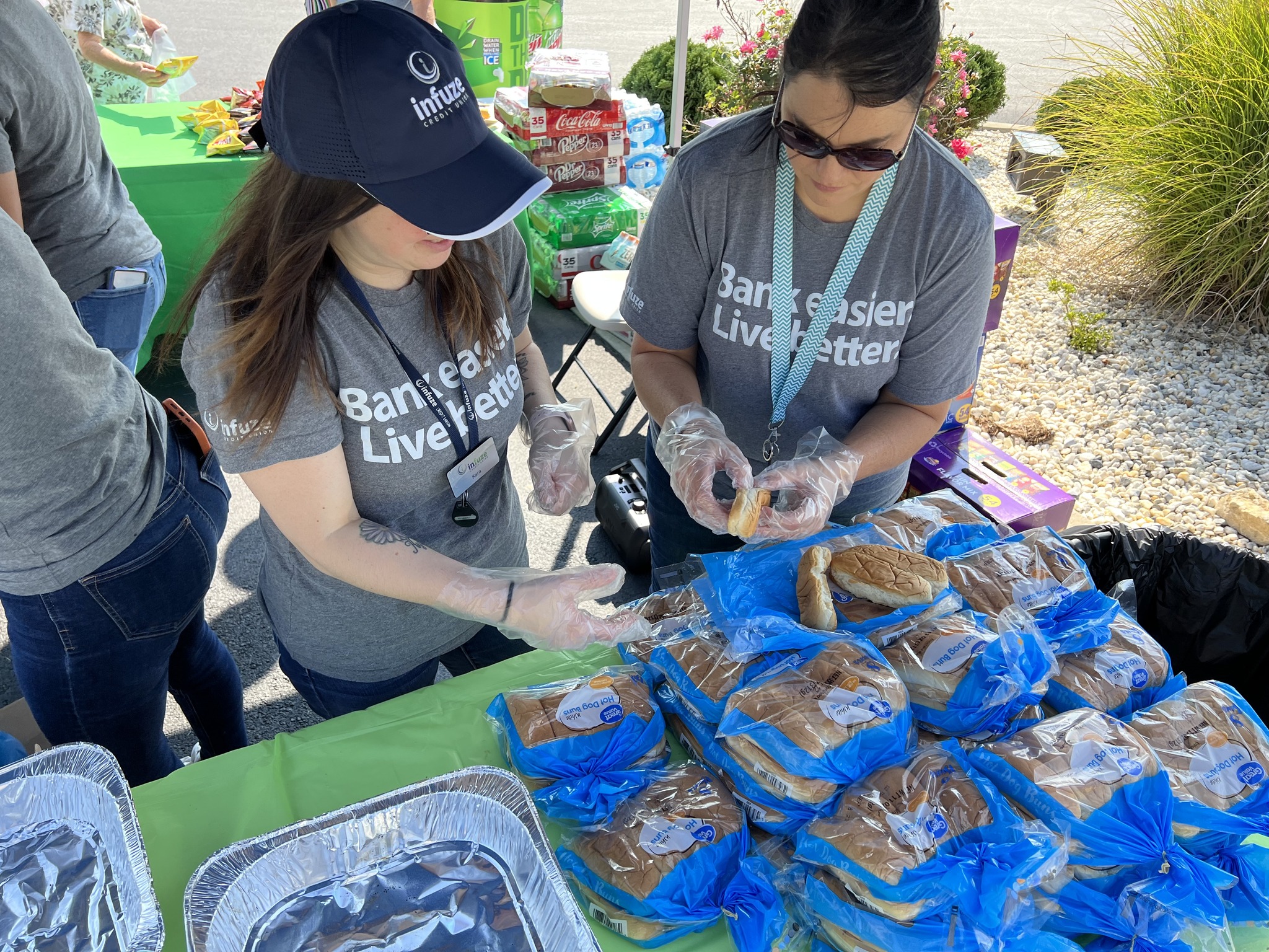 Two women preparing hotdogs.
