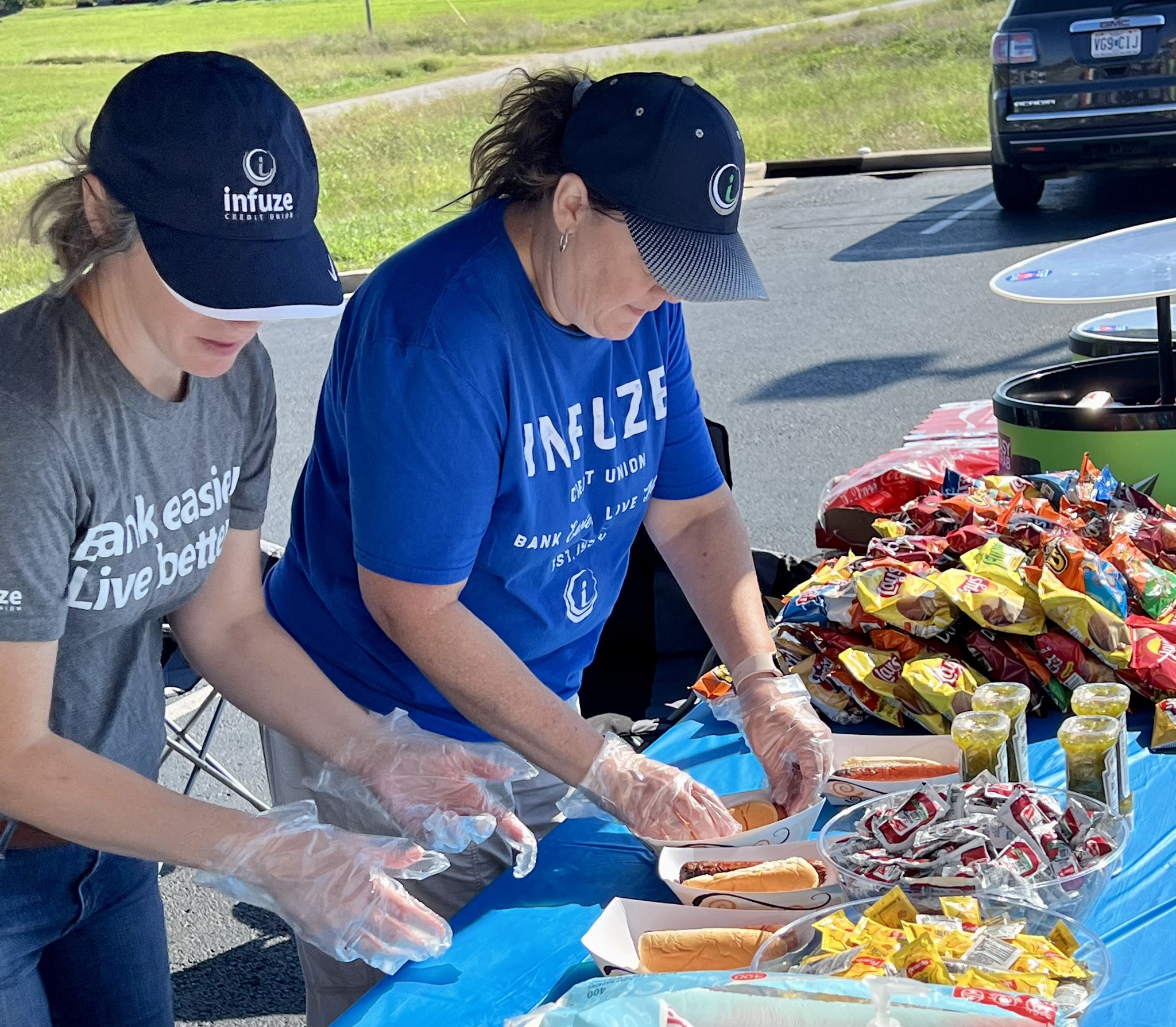 Two women preparing hot dogs.