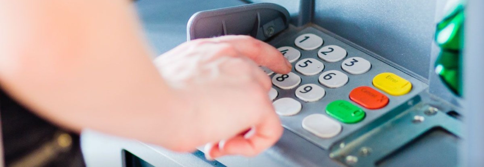 person pressing buttons on an ATM machine