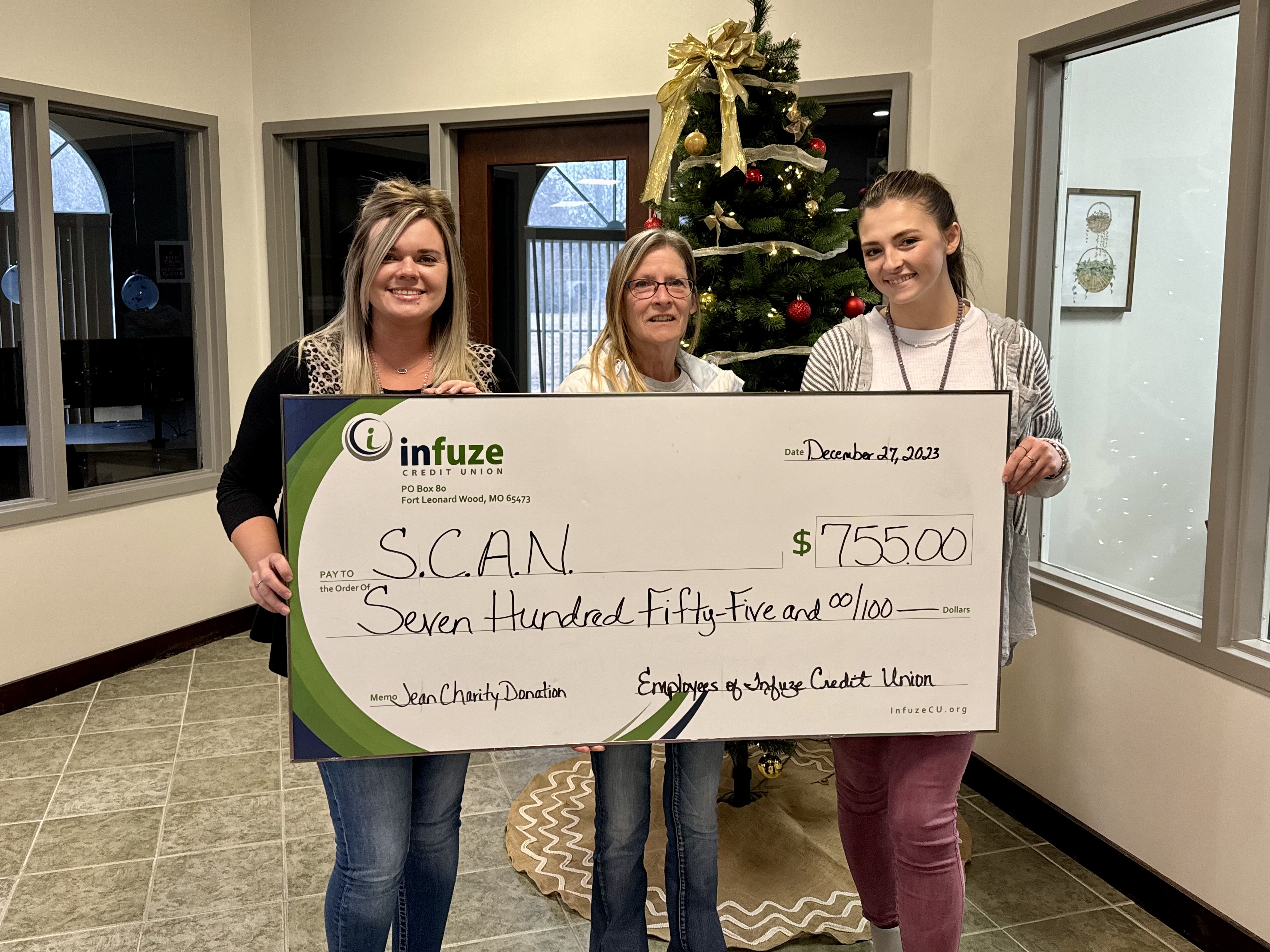 Three women holding novelty check.