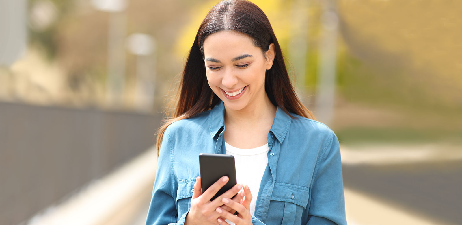 Smiling young woman checking phone.