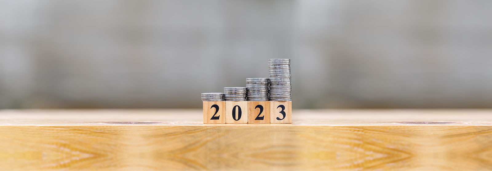 coins stacked on top of blocks reading 2023