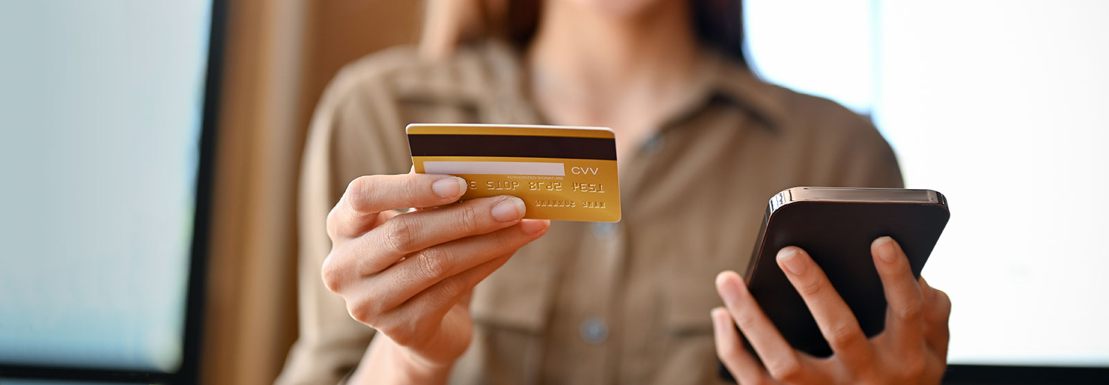 woman holding credit card and phone.