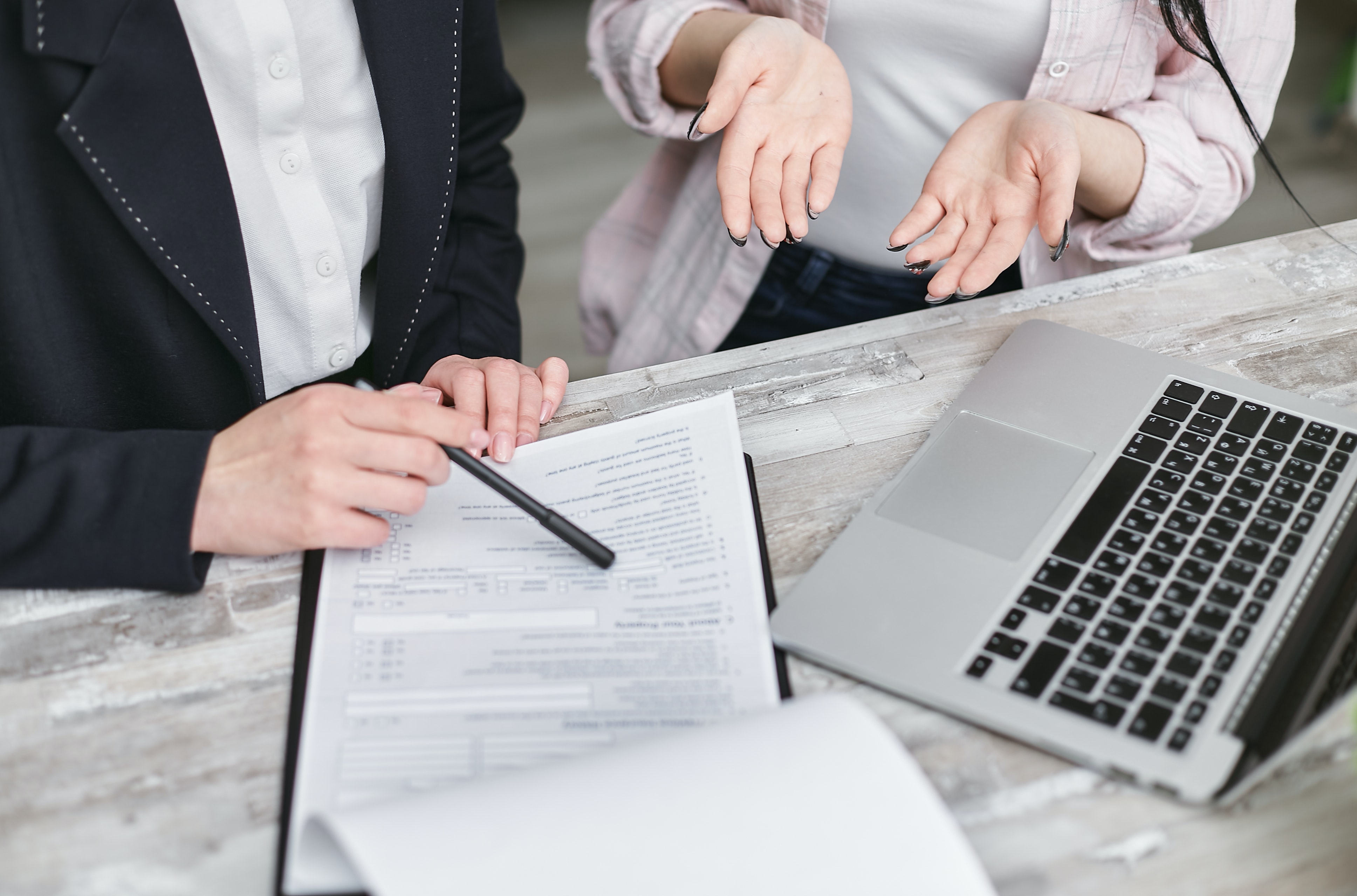 two people sitting and looking at paperwork.